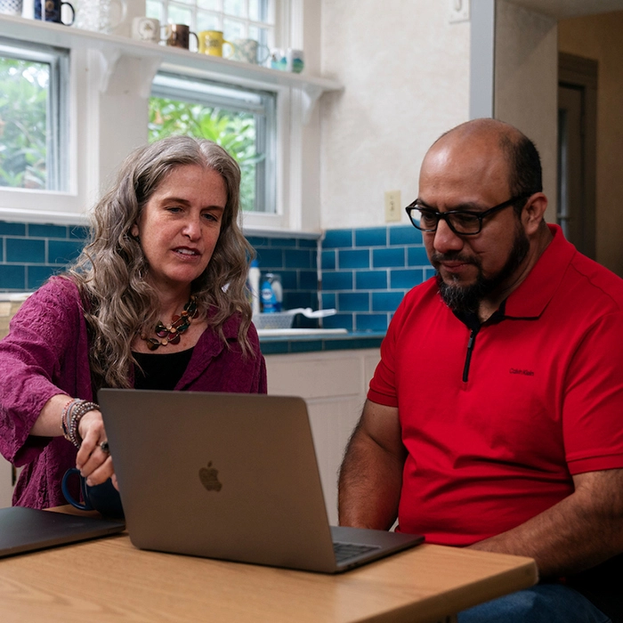 2 people working together on a laptop.