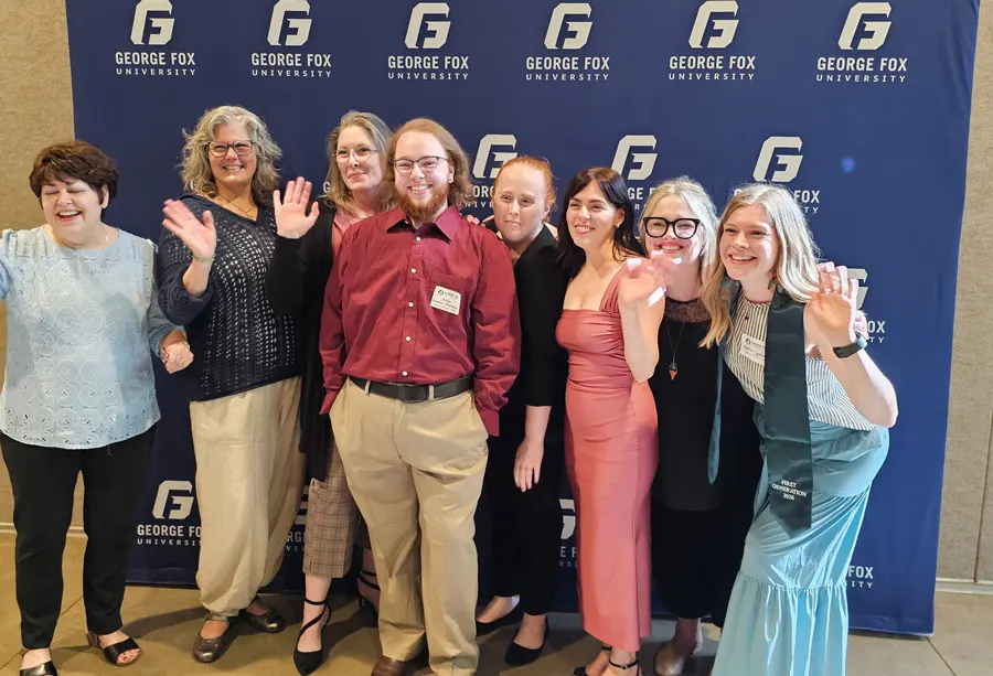 Vicki and her social work cohort in front of a George Fox University backdrop