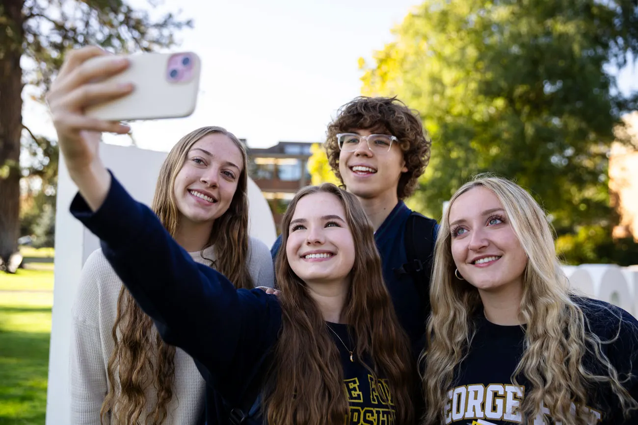 A group or 5 George Fox students take a selfie on the quad