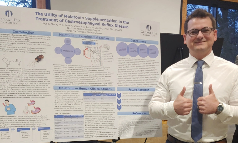 Sherer giving a thumbs up in front of his research poster at George Fox University