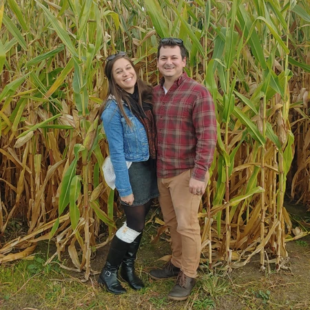 Sherer and his wife in front of a corn field