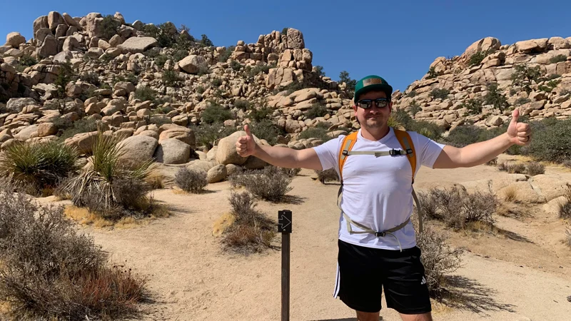 Sherer giving a thumbs up outside on a hike