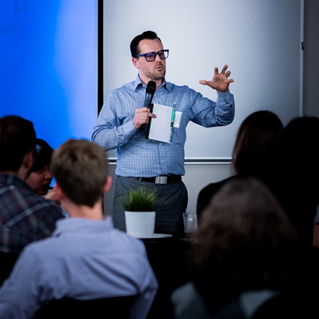 A speaker in front of a group of people at seminar