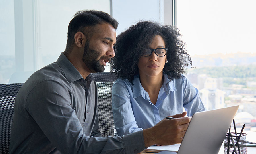 Two business professionals discussing over a laptop