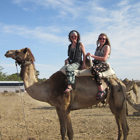 Two students riding on a camel