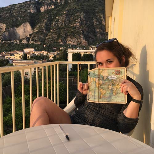 student holds journal in front of face