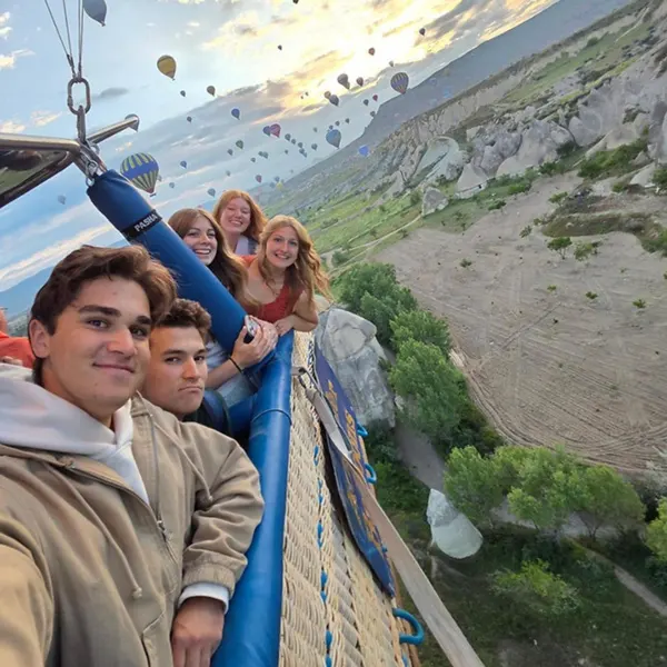5 students smile for a selfie in a hot air balloon