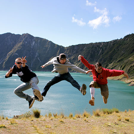 Three students jumping by the lake in Ecuador