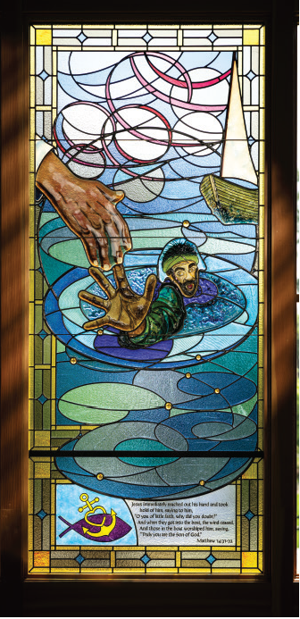 Stained glass window depicting Jesus rescuing Peter from the stormy waters, illustrating Matthew 14:31-32