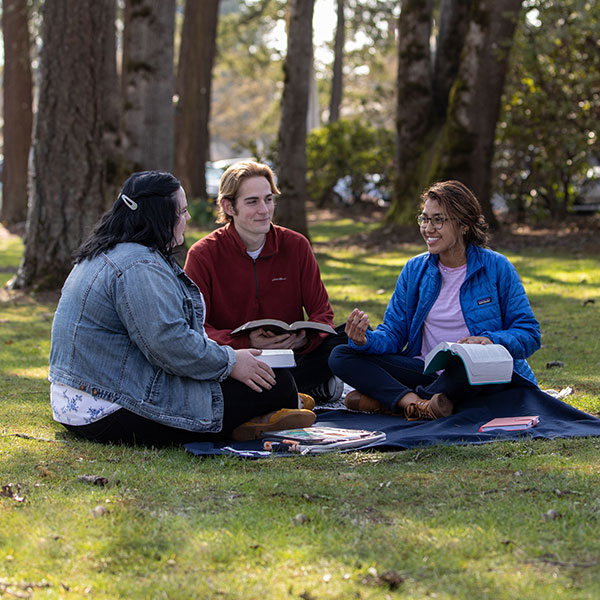 Three friends having a conversation while reading the Bible