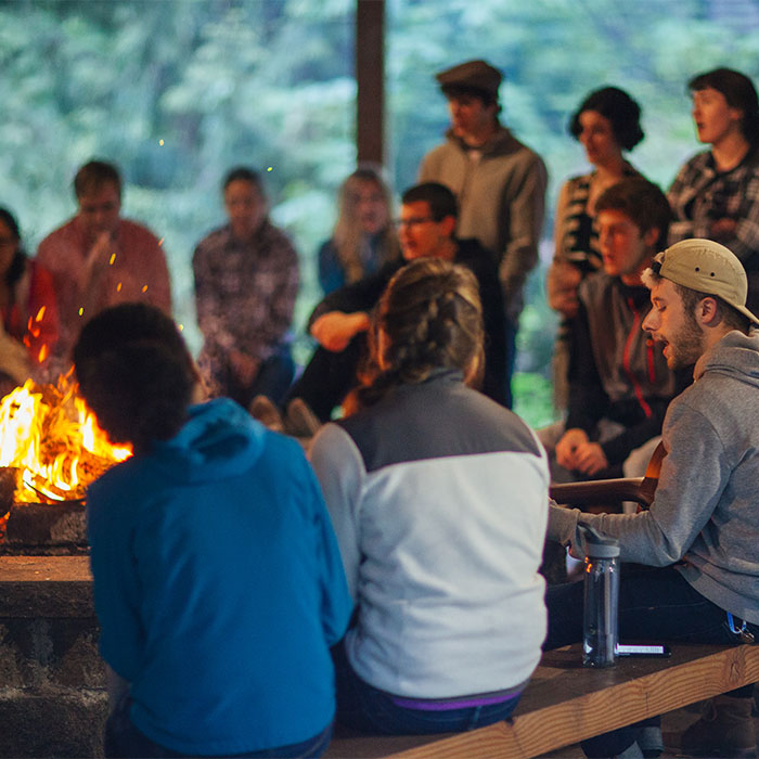 Students gather for a spiritual formation event around a camp fire