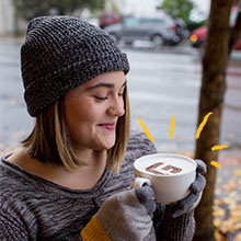 Student smiling with a cup of coffee