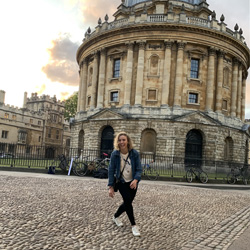Photo of a student standing in front of a historical building in Oxford, England