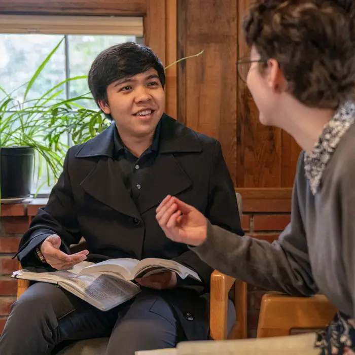 Two students engaging over a book