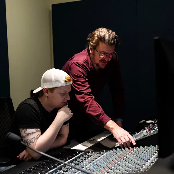 Associate Professor of Worship Arts and Music Industry Aaron Barnhart helps a student in the recording studio