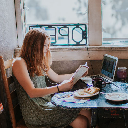 students reading a book in a coffee shop