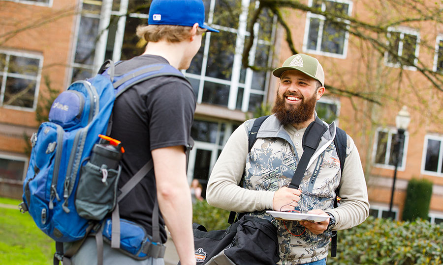 A happy student seeing his friend on campus