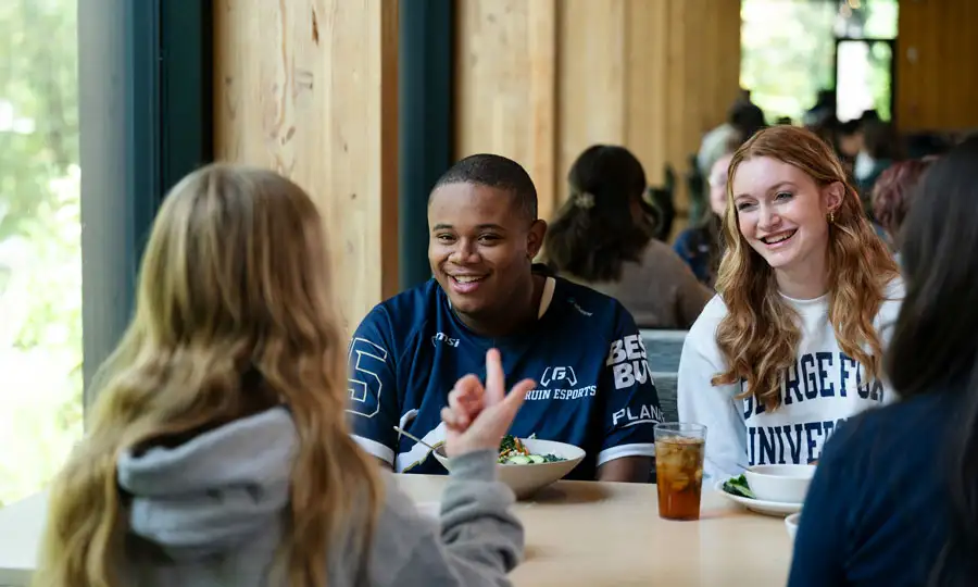 Students conversing around a booth at Canyon Commons over a meal 
