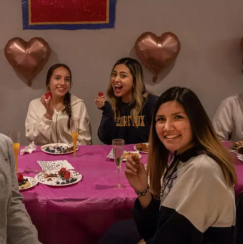 Three women sit and eat together for galentines day