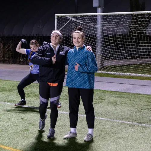 3 soccer club members smile and goof off for the camera