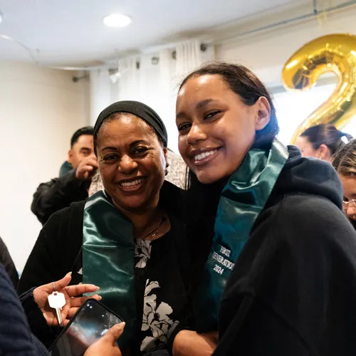 A student and her mom hug at the First-Gen graduation celebration