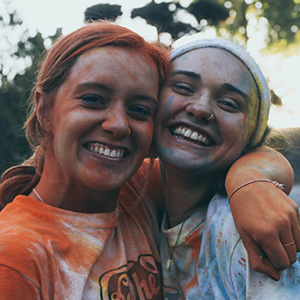 Two students whose faces are covered with colored chalk