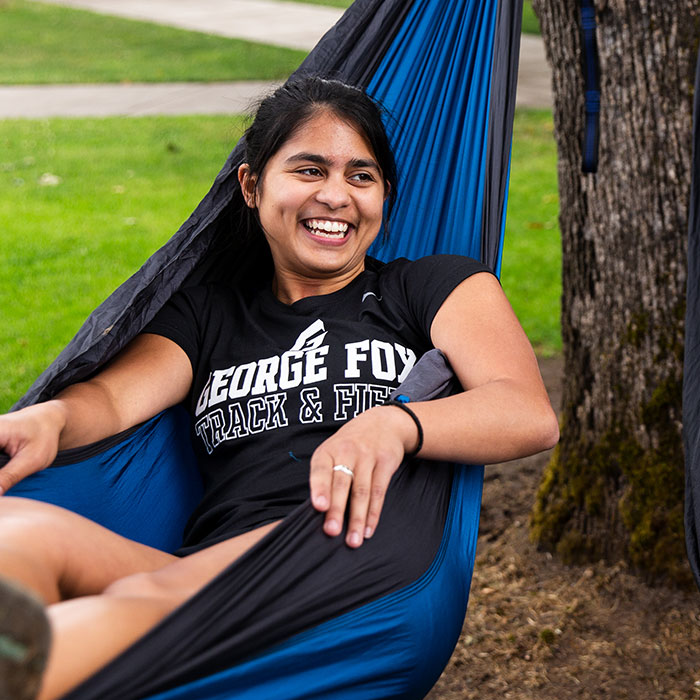 Happy student relaxing in a hammock on campus