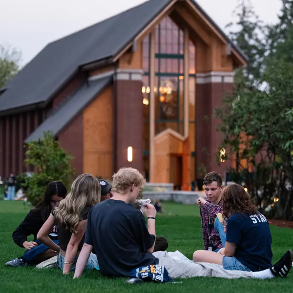 Students sit in a bible discussion group outside the chapel