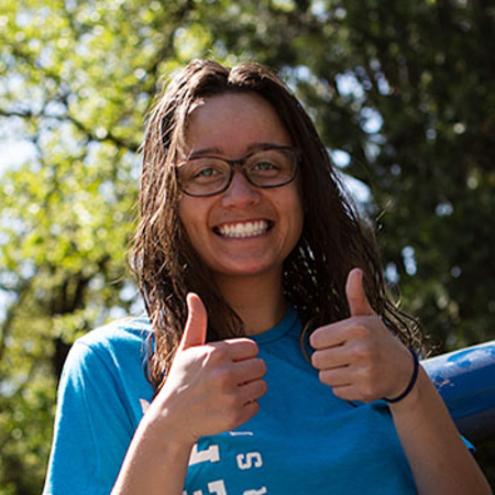 A Student of color with a big smile and two thumbs up