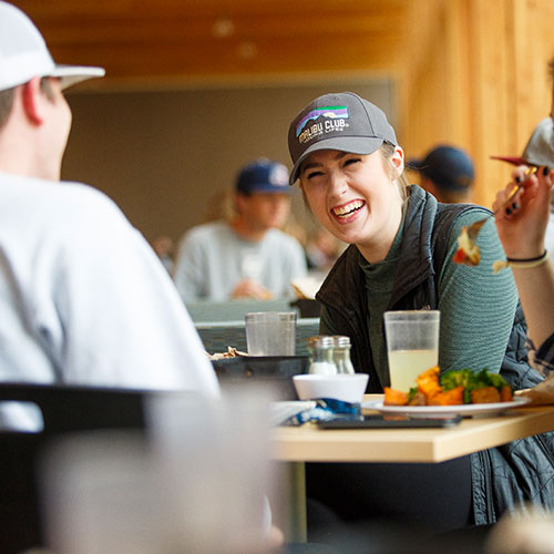 Students laughing with friends in the dining hall