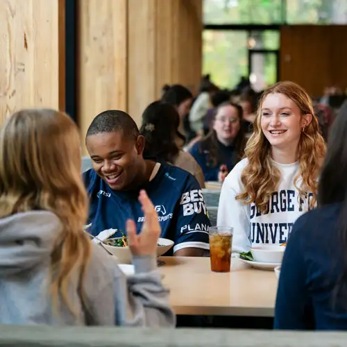Students laughing with friends in the dining hall