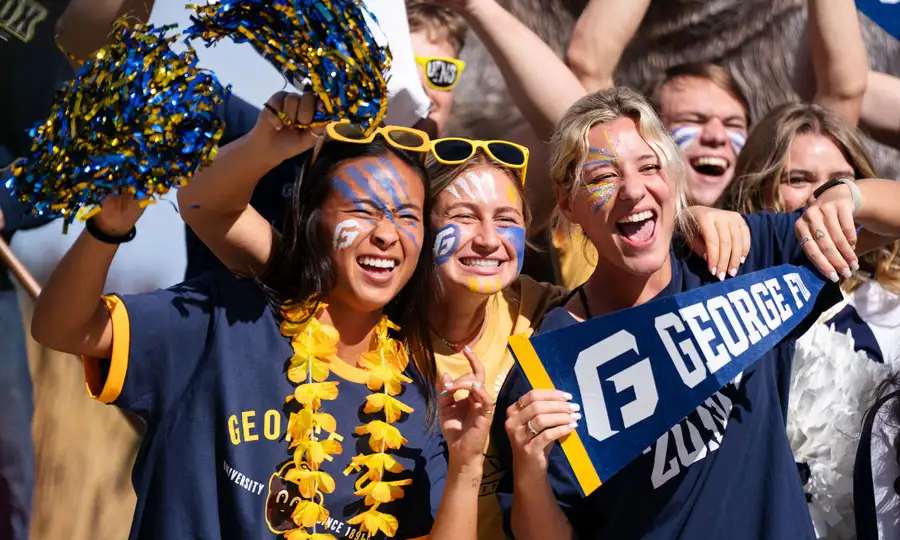 Students cheering in George Fox gear and face paint