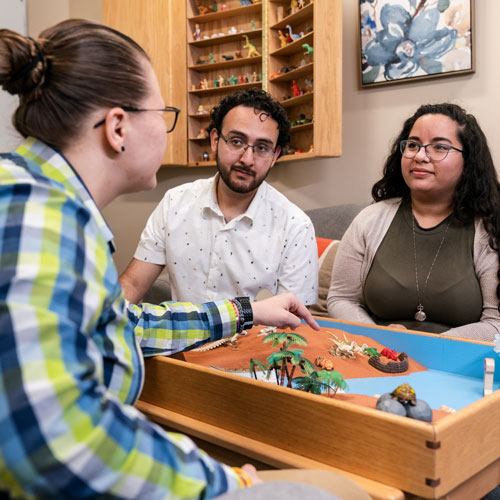 Two parents talk with a family counselor at a table