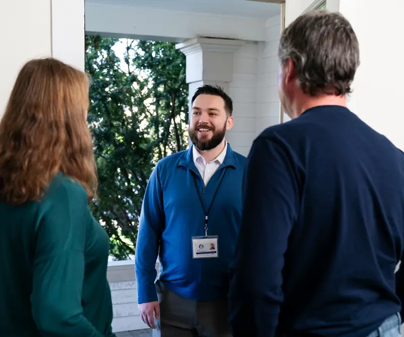Counselor greets a married couple on their front porch