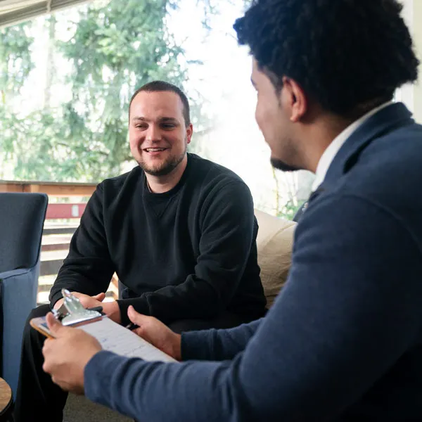 Counselor and client laugh during a mock session