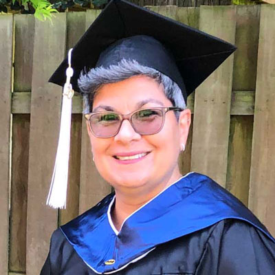 image of Diaz in black and blue graduation regalia 