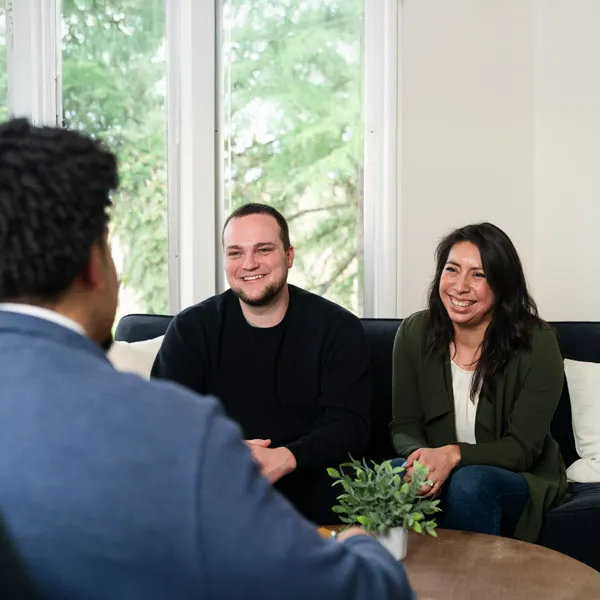 A married couple talk to a counselor in a sunny room