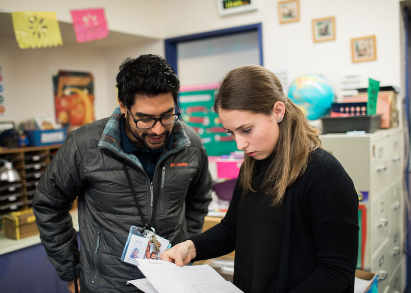 School teacher helps student teacher with course work