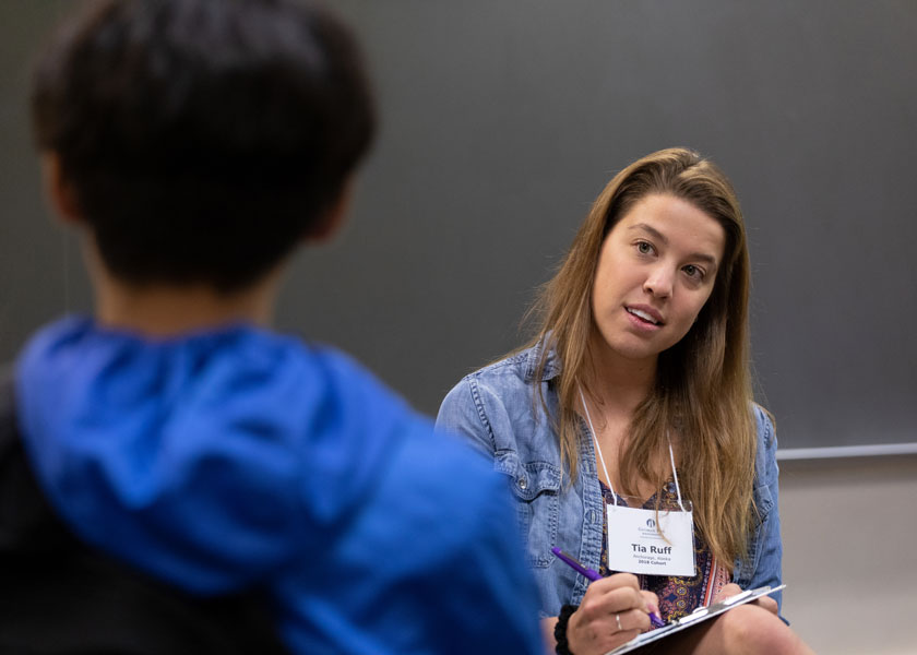 Female student teacher listens to young student