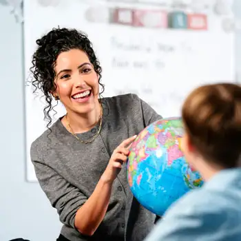 Teacher interacting with student in an elementary school classroom