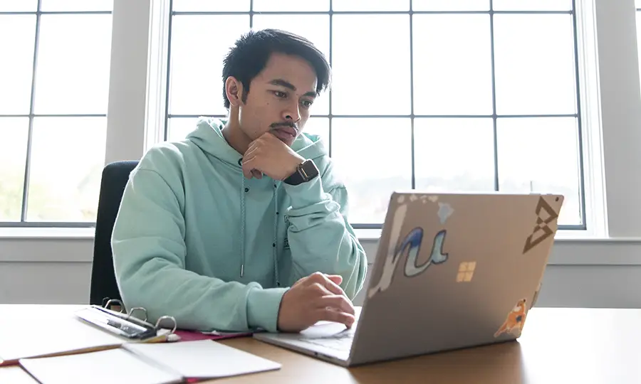 Student studying on his laptop