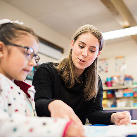 A teacher coaching her young student