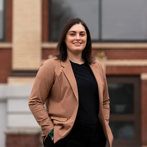 Teacher Brittany Morales smiles in front of her school