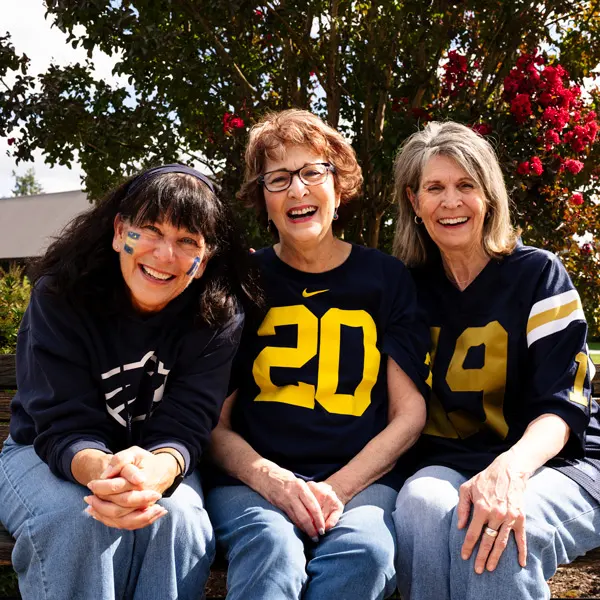 3 alumni from George Fox smile for a photo in their gear