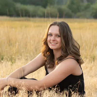 Anna smiles for a portait in a wheat field