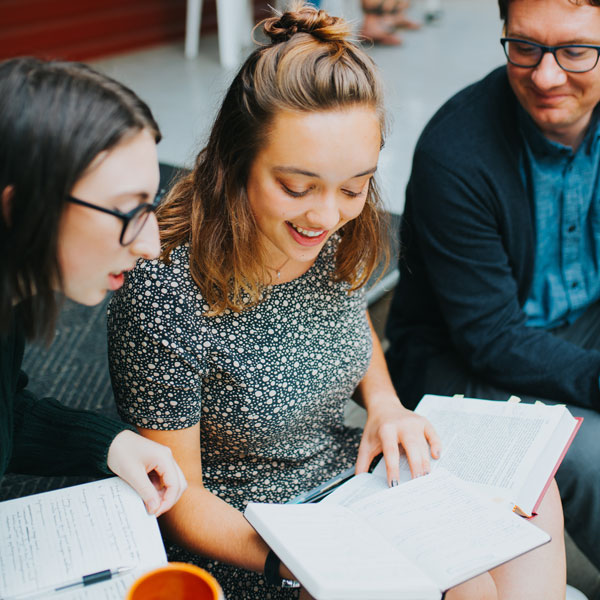 Professor talks passionately to students at a coffee shop