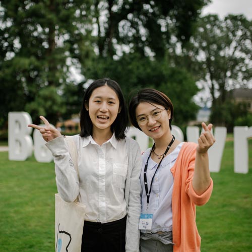 2 students smile on the quad