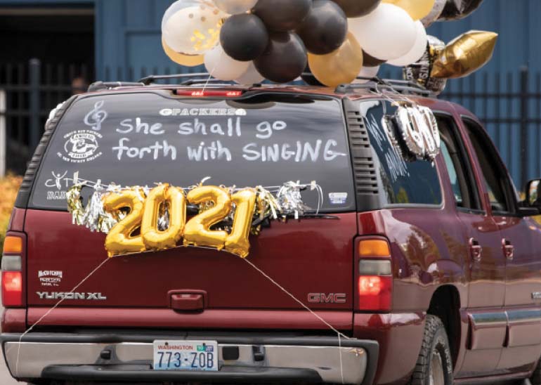 An SUV decorated with baloons has 'she shall go forth with singing' written on the back window