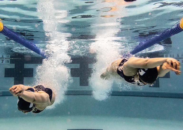 The Zucker twins underwater swimming towards the camera