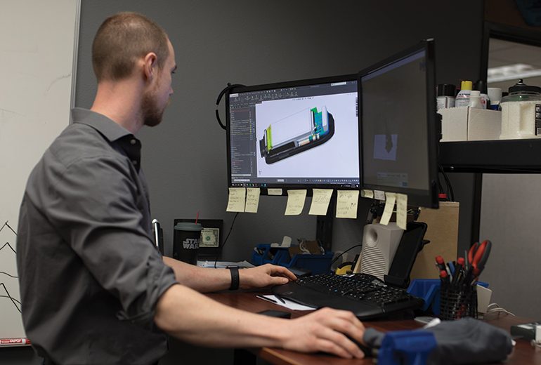 Mike Morrison examines a “solid model” of the Clarus cardiac monitor’s internal components on his computer.